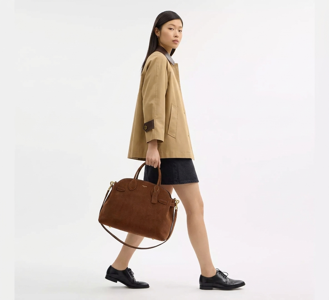 Coach — Model Holding Handbag Walking